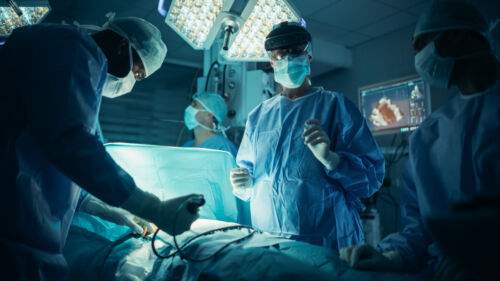 Operating Team Following Directions of a Female Surgeon Using Augmented Reality Headset, Where a Digital Overlay Helping to Streamline the Process During a Medical Operation with a Patient